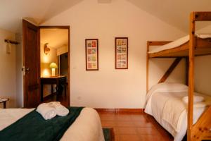 1 dormitorio con 2 literas y pasillo en A Saboeira - Turismo Rural en Belver