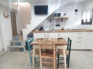 eine Küche mit einem Holztisch und Stühlen im Zimmer in der Unterkunft Casa Cueva La Luna in Setenil de las Bodegas