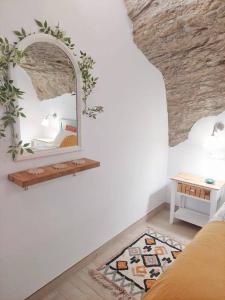 Zimmer mit einem Spiegel an der Wand und einem Tisch in der Unterkunft Casa Cueva La Luna in Setenil de las Bodegas