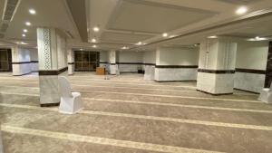 فندق منار التوحيد 2 في مكة المكرمة: غرفة كبيرة بها اعمدة وكرسي ابيض