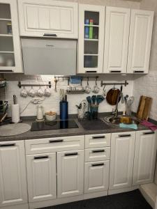 a kitchen with white cabinets and a sink at 2-х комнатная квартира in Pizunda