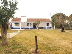 una casa blanca y azul con un patio de césped en Monte das Laranjeiras, en Cortiçadas do Lavre