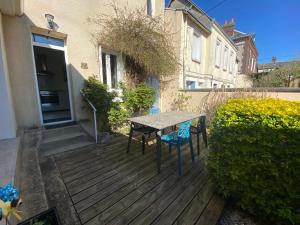 una terraza de madera con mesa y sillas. en La maison "Un air de vacances" - Rive gauche - 209, en Rouen