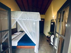a bedroom with a bunk bed with a mosquito net at Ambiente Guest House in Ella