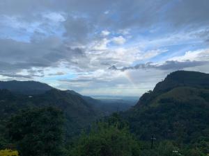 a rainbow in the sky over a mountain valley at Ambiente Guest House in Ella