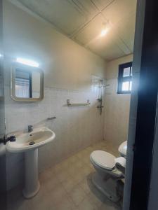 a bathroom with a toilet and a sink at Ambiente Guest House in Ella