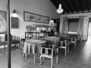 a restaurant with tables and chairs and a chandelier at Ambiente Guest House in Ella