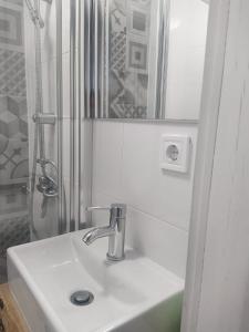 a white bathroom with a sink and a shower at Porto Grand Sasimi House in Porto