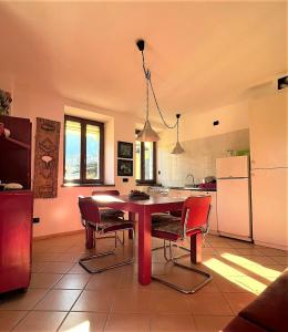 a kitchen with a table and chairs and a refrigerator at Casa Gialla - I in Molina di Ledro