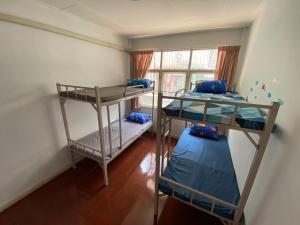 a room with two bunk beds and a window at Sura Hostel and Coworking in Bangkok