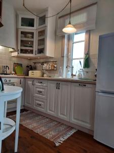 a kitchen with white cabinets and a white refrigerator at Na skraju lasu in Milejczyce