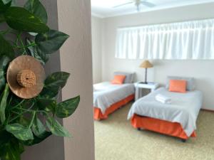 a bedroom with two beds and a room with a couch at Straebe Stay in Bloemfontein