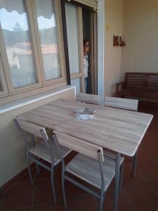 a wooden table and chairs in a room with a window at Appartamento Loretta in Marciana Marina