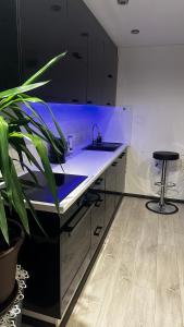a kitchen with a sink and a counter with a stool at Valmiera in Valmiera