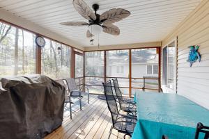 a screened in porch with a blue table and chairs at Trinity Place Treasure in Ocean Pines
