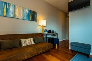 a living room with a brown couch and a blue chair at B&B il Duca d'Amalfi in Salerno
