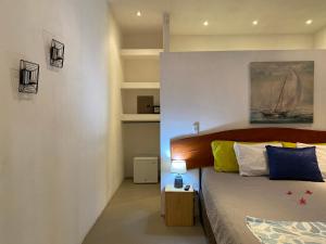1 dormitorio con 1 cama y una pintura en la pared en Antema Lodge Secteur Tamarindo, piscine, yoga, gym, jungle et paix en Tamarindo
