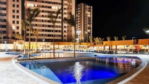 a large pool with blue water at night at Enjoy Solar das Águas Park Resort in Olímpia