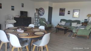 Une escapade en Luberon في بونيو: غرفة معيشة مع طاولة وكراسي وأريكة
