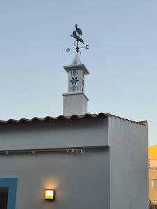 een klokkentoren bovenop een wit gebouw bij Casa Tradicional Algarvia in Lagoa