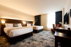 um quarto de hotel com duas camas e uma secretária em Pickering Casino Resort em Pickering