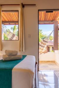a bedroom with a bed and a view of a hammock at Pousada Capitão Thomaz in Jericoacoara
