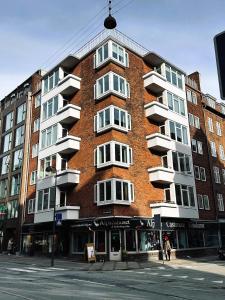 un gran edificio de ladrillo rojo en una calle de la ciudad en ApartmentInCopenhagen Apartment 1423, en Copenhague