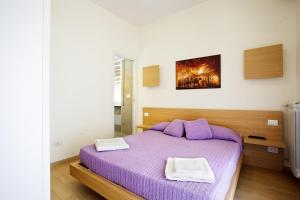 - une chambre avec un lit violet et 2 serviettes dans l'établissement Affittacamere Nansen, à Rome