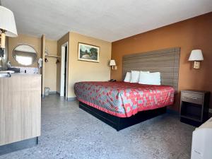 een hotelkamer met een bed met een rode sprei bij THE COUNTRY CORNER INN in Devine