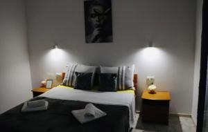 una camera da letto con un grande letto con due comodini di Iva apartman sa bazenom a Donji Zemunik