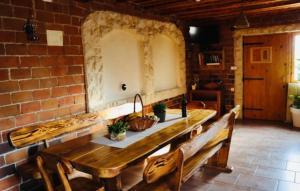 Habitación de ladrillo con mesa de madera y bancos en Iva apartman sa bazenom en Donji Zemunik