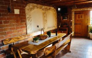 a brick room with a wooden table and benches at Iva apartman sa bazenom in Zemuniki