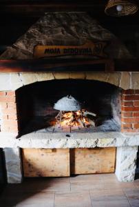 un horno de ladrillo con un fuego dentro de él en Iva apartman sa bazenom en Donji Zemunik