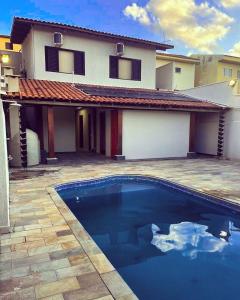 uma casa com piscina em frente a uma casa em Pousada & Hostel São Carlos em São Carlos