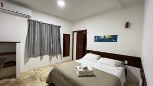 En eller flere senge i et værelse på Aki Pousada