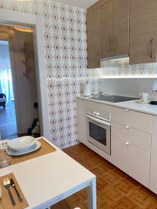 a kitchen with white cabinets and a white table at Guest house Croqueta Espinardo in Espinardo