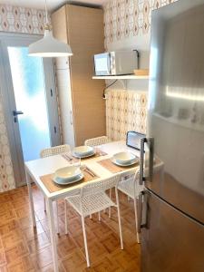 y cocina con mesa, sillas y nevera. en Guest house Croqueta Espinardo en Espinardo