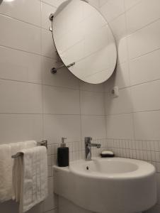 ein weißes Badezimmer mit einem Waschbecken und einem Spiegel in der Unterkunft Bella vista - cozy apartment with a great view in Split