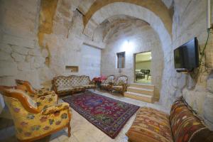 - un salon avec des chaises et une télévision dans un mur en pierre dans l'établissement View Cave Hotel, à Gorëme