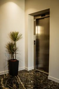 um corredor com elevador e um vaso de plantas em Sonio Boutique Hotel em Mamaia