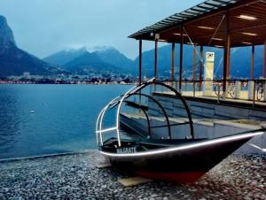 a boat sitting on the shore of a body of water at VerdeLago Como Lake in Malgrate