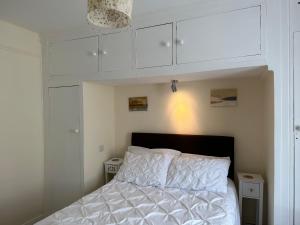 1 dormitorio con 1 cama con armarios blancos en The Durbeyfield Guest House en West Bay