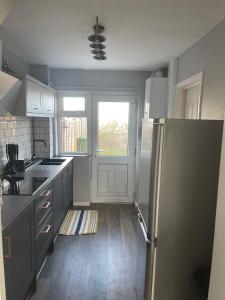 a kitchen with a stainless steel refrigerator and a window at II comfortable room, Shared House in Bristol