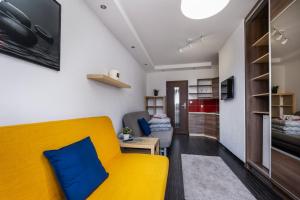 a living room with a yellow couch and a table at Villa Lordis in Krynica Morska