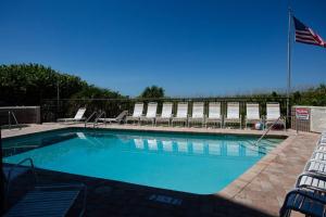 a swimming pool with chairs and an american flag at 306 - Gulf Strand in St. Pete Beach