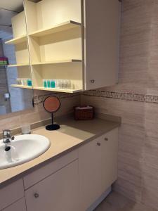 een badkamer met een wastafel en een spiegel bij Apartamento Es Calo (Edificio Cavall de Llevant) in Es Calo