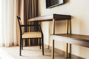 a chair sitting next to a wooden table at Sonio Boutique Hotel in Mamaia