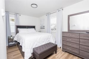 een slaapkamer met een bed, een dressoir en een spiegel bij Beautiful Remodeled Home 3 BD 1 BTH w Hot Tub in Spokane Valley