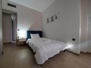een slaapkamer met een groot wit bed en een nachtkastje bij Endless View Apartment in Nafplio