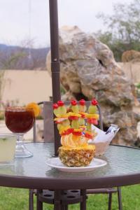 - une table avec une assiette de fruits et une boisson dans l'établissement Hotel y Restaurante Villas Del Sol Jalpan, à Jalpan de Serra